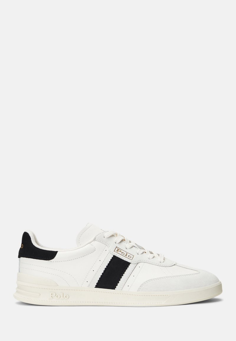 Baskets basses blanches avec bandes latérales noires et détail au talon, fermeture à lacets et logo Polo sur le côté et la semelle.