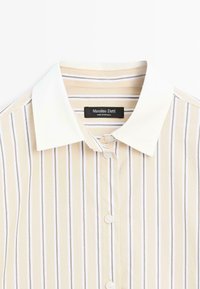 Striped shirt featuring a soft beige fabric with white and light brown vertical stripes, a classic collar, and front button closure.
