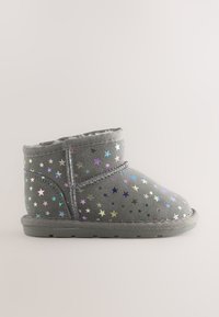 Šedá kotníková bota vyrobená z mäkkého materiálu, ktorá má po povrchu farebné hviezdne vzory a plochú gumovú podrážku.