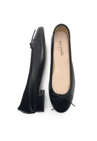 Ballerine in pelle nera con punta arrotondata, piccolo tacco a blocco e un fiocco decorativo sulla parte anteriore. Morbida fodera interna con dettagli del logo.