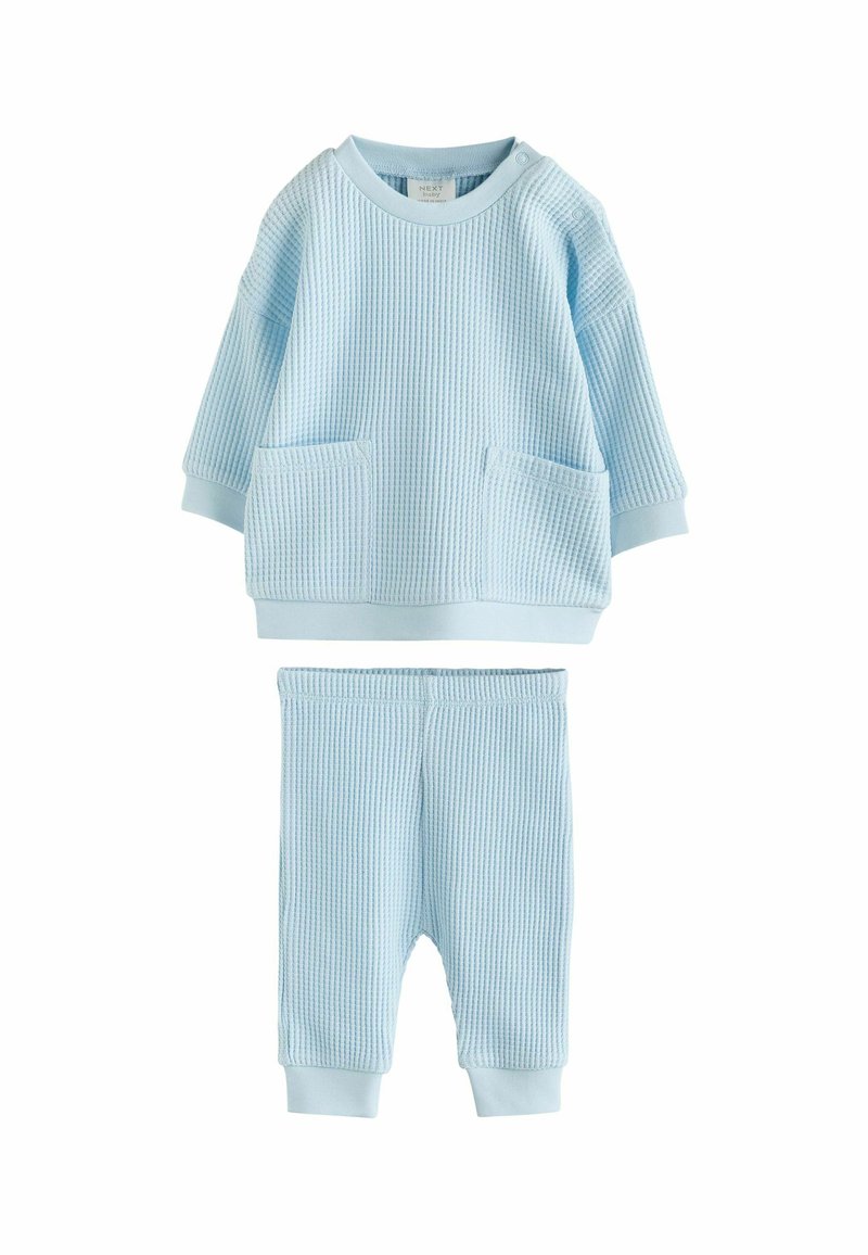 Lichtblauw gebreid twee-delig setje met een lange mouw top met ronde hals en zakken, gecombineerd met broek met elastische tailleband.