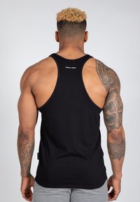 Fekete ujjatlan tank top kerek nyakkivágással és sportos hátrészi dizájnnal, hátul egy kis "Gorilla Wear" logóval.