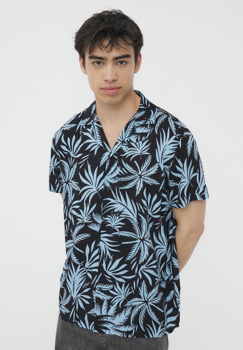 Camicia a maniche corte con bottoni in tessuto nero con un motivo di foglie tropicali blu, dotata di colletto e con una vestibilità rilassata.