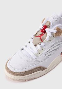 Valge nahast tennisetoss, millel on beežist nubukist aksessuaarid, punane Jumpman-logo ja ventilatsioonipaneelid külgedel. Paeltest sulgemine ja tekstureeritud kummist tallad.