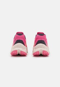 Zapatillas de trail con parte superior de malla en rosa oscuro y azul marino, suela acolchada con una entresuela blanca moteada y una suela exterior de goma rosa prominente.