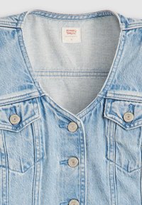 Jasnoniebieska kurtka dżinsowa z dekoltem w szpic, srebrnymi guzikami, dwiema kieszeniami na piersi i widocznymi przeszyciami. Na metce napis "Levi's."