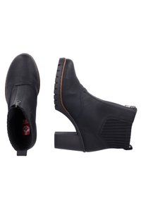 Botines negros de cuero, con un panel texturizado, tacón bajo y cremallera lateral. Suela de goma con patrón acanalado para mayor tracción.