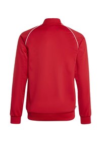 Czerwona sportowa kurtka z kołnierzem typu stójka, długimi rękawami, ściągaczami na mankietach oraz gładką fakturą. Cienkie białe przeszycia wzdłuż ramion.