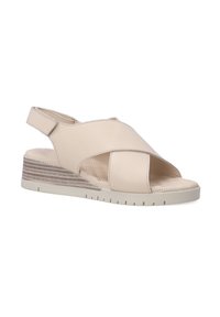 Beige slingback sandal with a crisscross design, made of smooth leather, featuring a textured platform and rubber sole for traction.