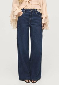 Jean large bleu foncé à taille haute, fabriqué en denim, avec des poches avant et une fermeture à bouton classique.