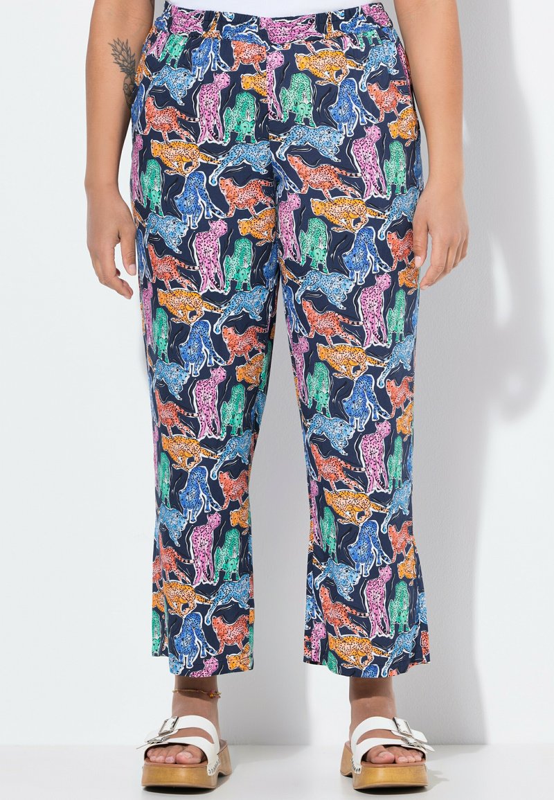 Farverige, mønstrede bukser med en blanding af leoparder i orange, grøn, pink og blå på en marineblå baggrund. Udvidet ben-design, elastisk talje.