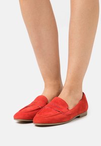 Rote Wildleder-Loafer mit flachem Absatz, ausgestattet mit einer glatten Oberfläche, dekorativen Nähten und einem runden Zehendesign.