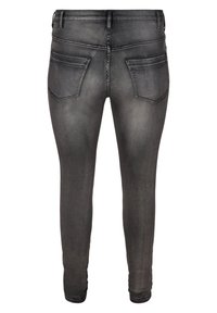 Jeans skinny de denim negro con un acabado desgastado, que cuentan con dos bolsillos traseros y detalles de costura sutiles. Material elástico para mayor comodidad.