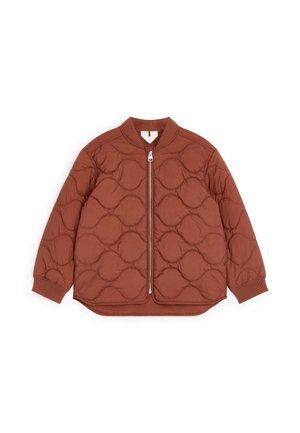 Veste matelassée brun rouille avec motifs de couture circulaires, fermeture éclair devant, poignets et col côtelés, conçue pour la chaleur et le confort.