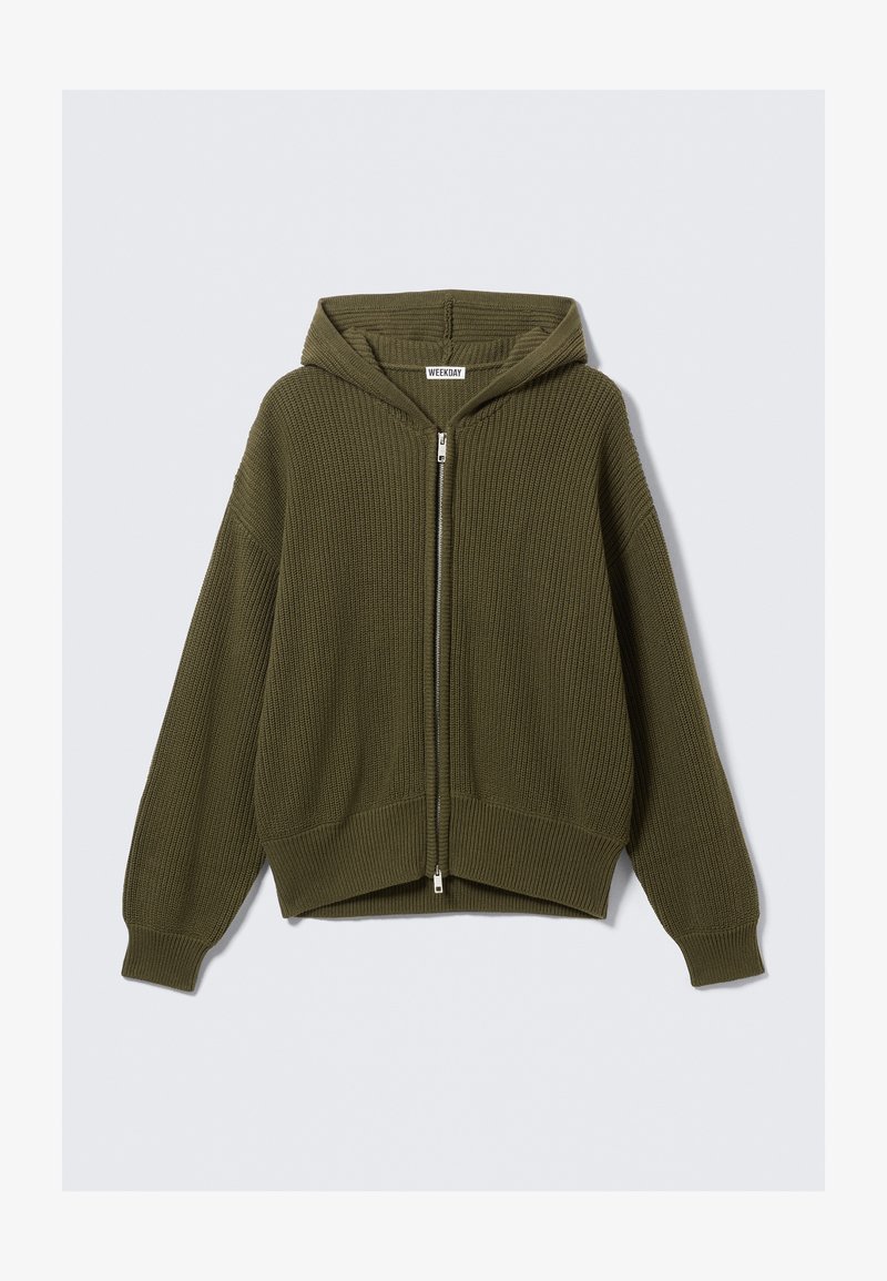 Oliven grønn hettejakke med glidelås, ribbestruktur, senkede skuldre og kort passform. Har en sølvfarget glidelås og brede mansjetter.