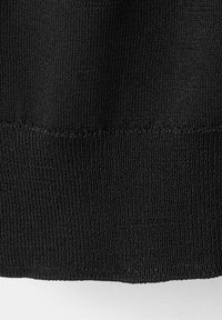 Tissu tricoté noir avec un bord retroussé montrant un motif de tissage fin et dense et un détail de couture horizontale.