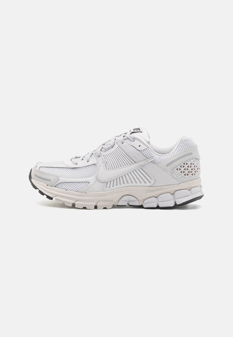 Chaussure de running blanche Nike avec dessus en mesh et synthétique, semelle amortie et logo Nike visible sur le côté, vue de profil.