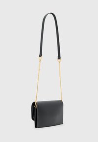 Borsa a tracolla in pelle nera con una superficie liscia, dotata di una tracolla in catena dorata e di una forma rettangolare, piegata sui lati.