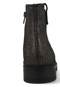 Bottine noire à finition métallique texturée, à bout rond et semelle épaisse en caoutchouc avec un talon, maintenue par une languette à l'arrière.