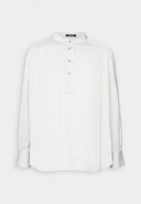 Camicia bianca a maniche lunghe con colletto alla mandarino, con bottoni e leggero luccichio. Presenta delle pieghe sulle spalle e un orlo curvo.