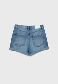 Denimshorts i ljusblått med vända upp kanter, med två bakfickor och en platt midja, visar en märkesetikett i mitten.