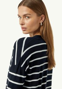 Navy gestreifter Pullover mit weißen horizontalen Linien, lockerer Passform und rundem Halsausschnitt. Das Material wirkt weich mit einer glatten Textur.