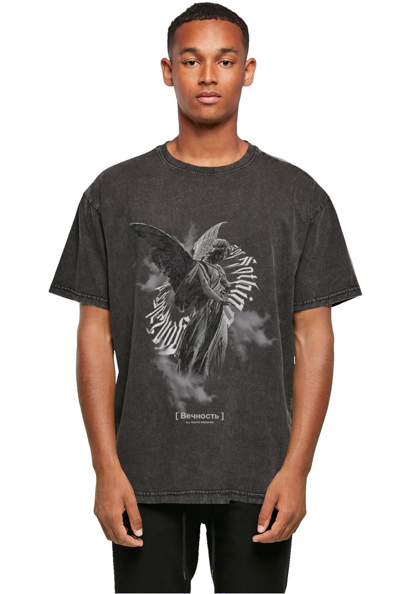 Sort, oversized t-shirt med et grafik af en vinget figur omgivet af svulmende tekst. Har en falmet, slidset tekstur.
