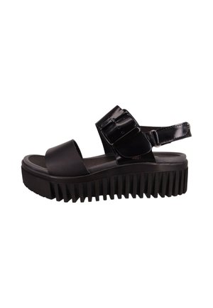 Sandalias de plataforma negras con suela gruesa, material superior brillante, correa ancha y hebilla ajustable. Suela texturizada con estrías verticales.