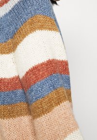 Sweter z dzianiny w paski z szerokimi pasami w kolorach kremowym, niebieskim, rdzaowym i tan. Miękka tkanina o luźnym kroju i okrągłym dekolcie.