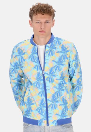 Giubbotto bomber leggero con sfondo blu e stampe colorate di foglie di palma, chiusura frontale con zip e polsini e orlo a coste di colore blu uniforme.