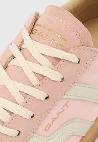 Hele roosa seemisnahast toss, millel on kreemivärvi paelad, kuldne bränding ja valged triibud küljel. Tekstureeritud pealmine osa kontrastse kummist tallaga.