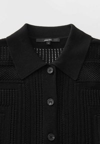Schwarze Strickjacke mit Kragen, Knopfverschluss mit vier Knöpfen und einem strukturierten, gemusterten Design über den Stoff.