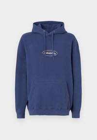 Námořnický modrý hoodie vyrobený z měkké tkaniny, s klokánkovou kapsou, nastavitelnými šňůrkami a logem na hrudi. Srolované rukávy a lem.