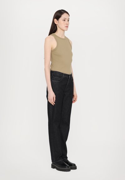 Top sin mangas color tostado, con cuello alto; jeans de mezclilla negros de pierna ancha con bolsillos delanteros; botas de plataforma negras. Diseño minimalista, colores sólidos.