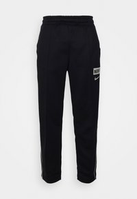 Svarta sweatpants med elastisk midja, sidostråkar och kontrasterande Nike-logotypapplikationer på låret och underbenet. Mjuk tygkvalitet.