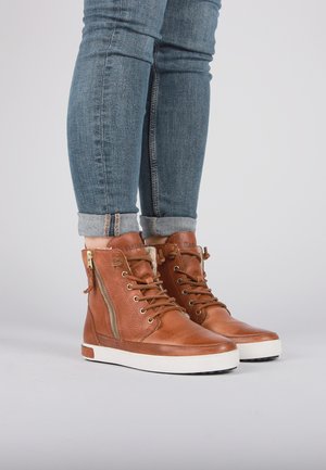 Sneakers alta in pelle marrone con finitura texture, suola bianca piatta, lacci frontali e dettaglio zip laterale.