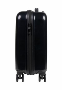 Valigia rigida nera con finitura lucida, chiusura a doppia zip, quattro ruote e forma rettangolare compatta. Dettagli hardware minimi.