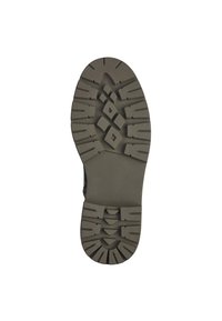 Semelle de chaussure noire avec des reliefs profonds, présentant un mélange de formes angulaires et de diamants pour une meilleure adhérence. Surface texturée avec une finition mate.