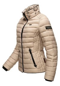 Beige polstret jakke med høy krage, svart glidelås og glidelåslommer med svarte detaljer og merkevare på ermet. Teksturert overflate.