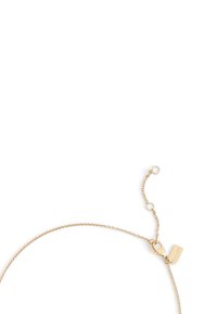 Bracelet en chaîne dorée avec un fermoir mousqueton et longueur adjustable. Présente une petite étiquette pour le branding. Design fin et délicat.