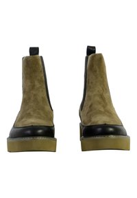 Botas de tobillo de ante marrón con acentos en cuero negro, paneles elásticos laterales y suelas de goma. El diseño presenta una punta redondeada y un tacón bajo.