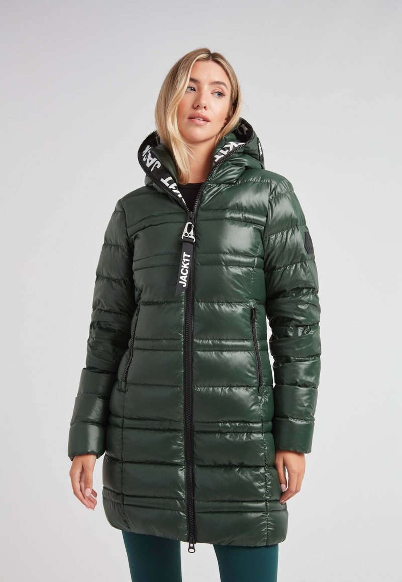 Abrigo acolchado verde con textura brillante, diseño de acolchado horizontal, cremallera negra y capucha con forro interior de marca. Mangas largas y bolsillos laterales.