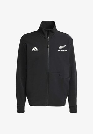 Sort zip-up jakke lavet af blødt materiale. Har hvidt logo og accenter på brystet, med høj krave og sidelommer.