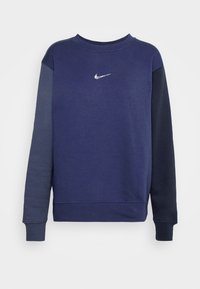 Mörkblå sweatshirt med långa ärmar, blandad bomullstyg, klassisk rund halsringning och en liten silverfärgad Nike-logotyp på bröstet.