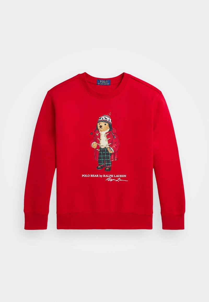 Sweatshirt rouge avec une illustration d'ours portant un manteau rouge et un pantalon en tartan. Le texte en dessous indique "POLO BEAR par RALPH LAUREN." Tissu doux, col rond.