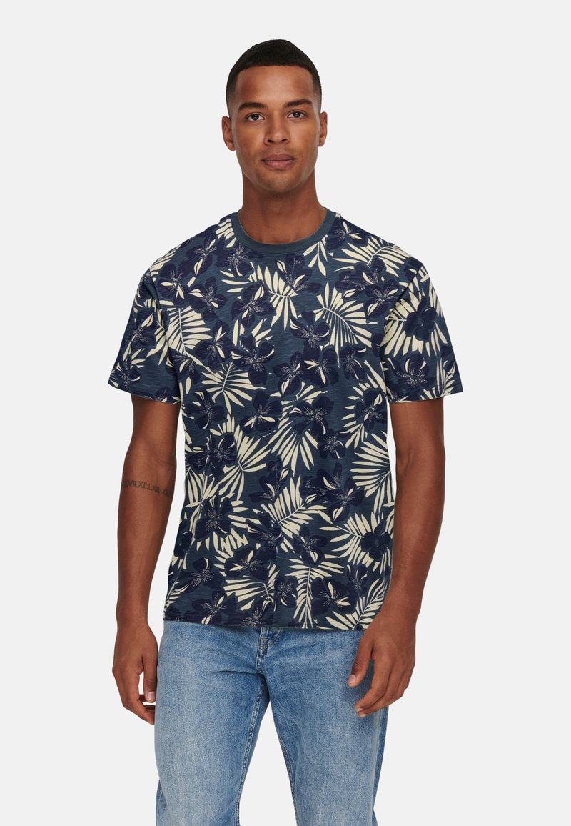 Camiseta de manga corta azul marino con un patrón floral en crema y verde. Hecha de un material suave, cuenta con cuello redondo y un ajuste relajado.