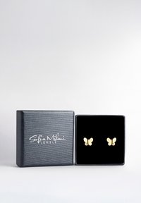 Goldfarbene, schmetterlingsförmige Ohrringe mit glänzender Oberfläche und kleinen, klaren Edelsteinen, präsentiert in einer strukturierten schwarzen Schmuckbox.