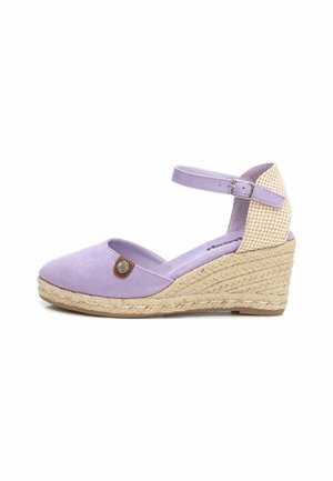 Zapato de cuña de ante púrpura con detalles de yute, correa al tobillo y punta redonda. Presenta un pequeño acento metálico en el costado.