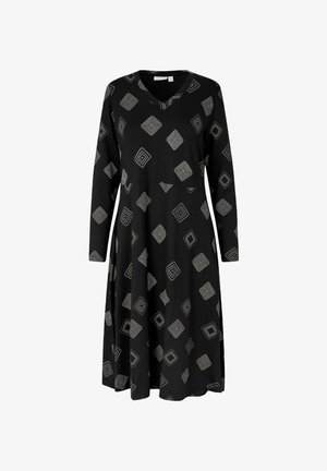 Czarna sukienka z miękkiego materiału, z dekoltem w kształcie litery V, długimi rękawami i geometrycznym wzorem w białe i szare kwadraty. Sylwetka A-line.