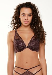 Bruine kanten beha met driehoekige cups, voorzien van een bloemenpatroon. Verstelbare bandjes en een decoratieve accent in het midden.